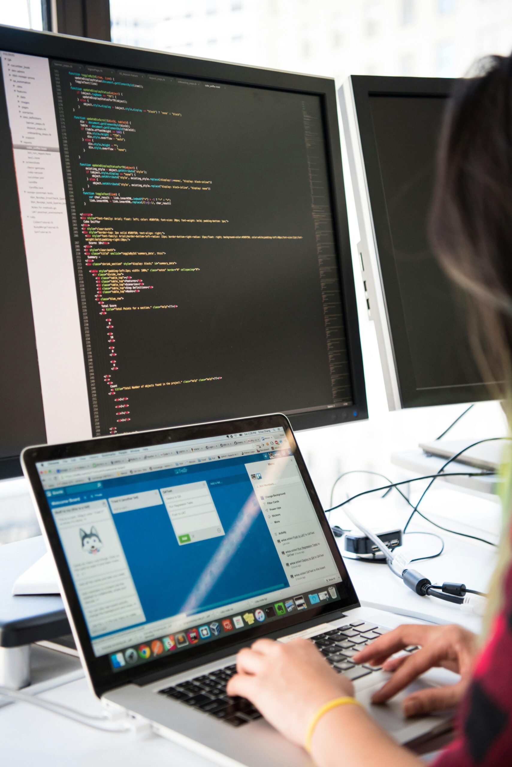 Programmers working on code across multiple screens